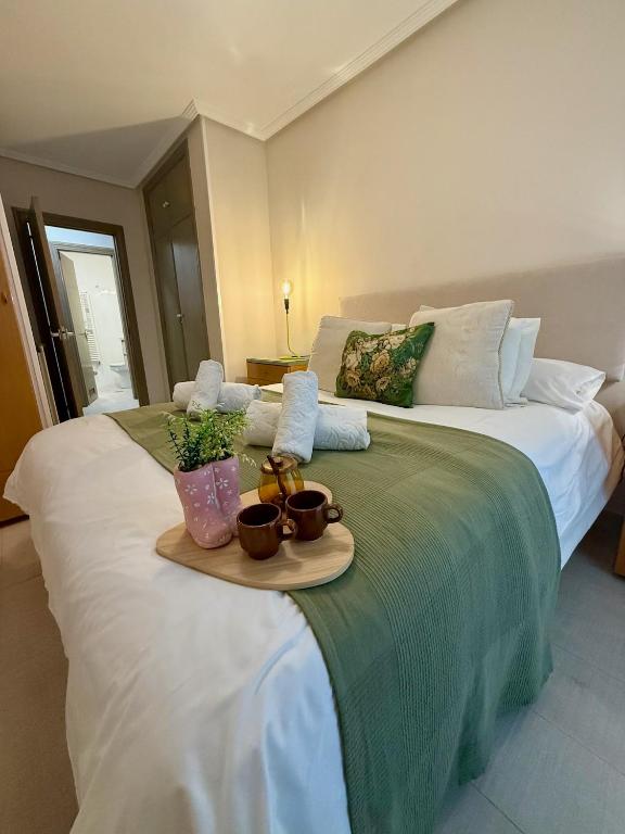 a large white bed with a tray of food on it at Apartamento Cimadevilla Plaza in Oviedo