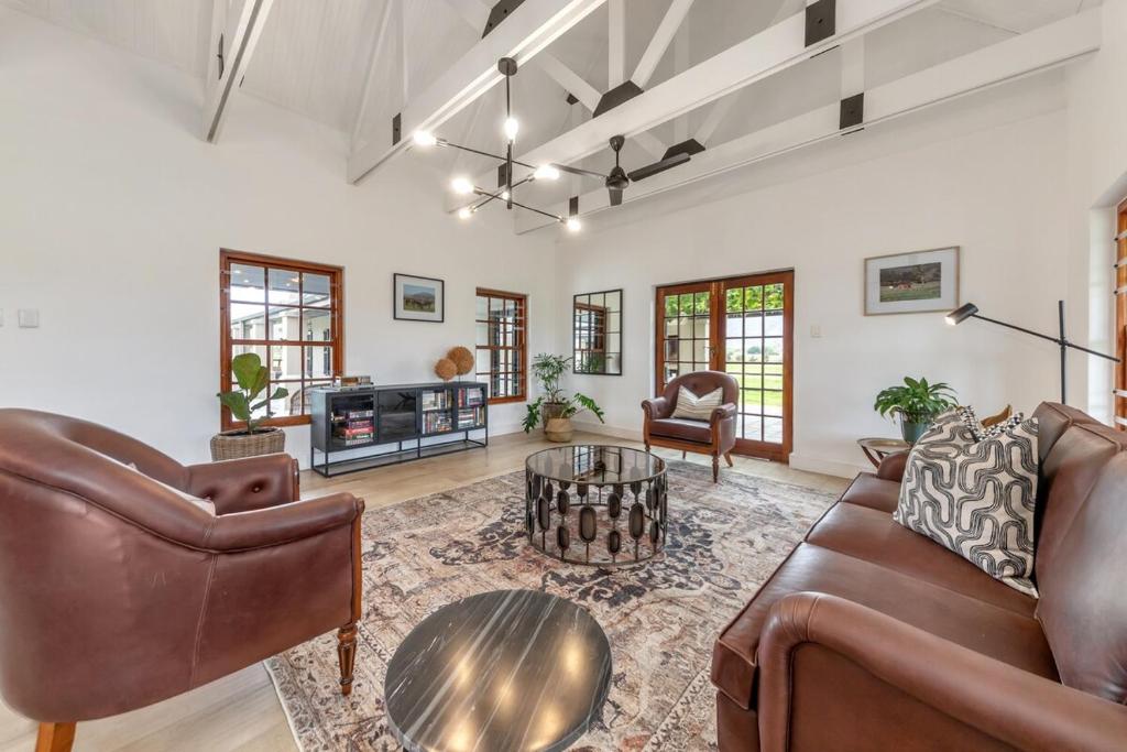 a living room with leather furniture and a table at Millstream manor guest house in Robertson