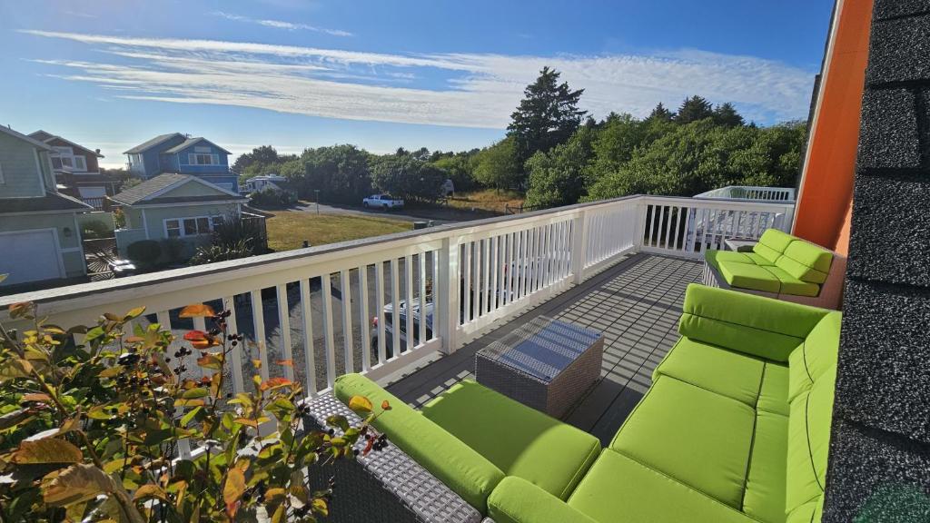 a balcony with two green chairs and a view of the ocean at Sunkissed 3BR Oceanview, Dog-Friendly Beach Home in Pacific Beach