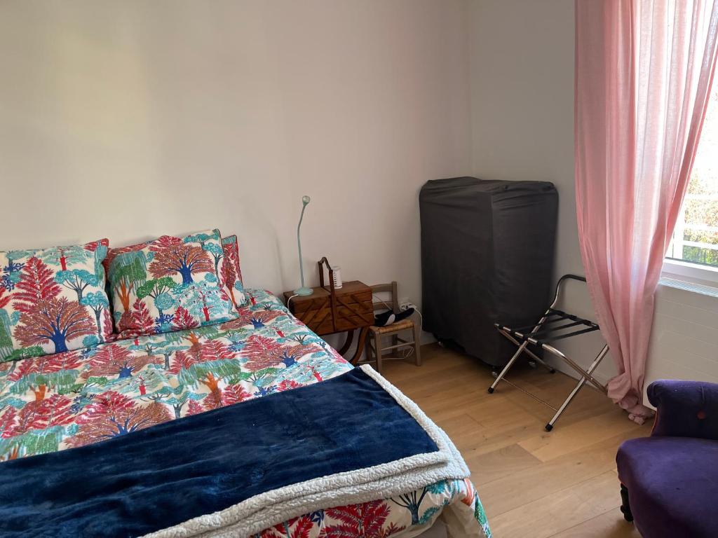a bedroom with a bed and a flat screen tv at Amélia HOST chambre climatisée in Saint-Rémy-lès-Chevreuse
