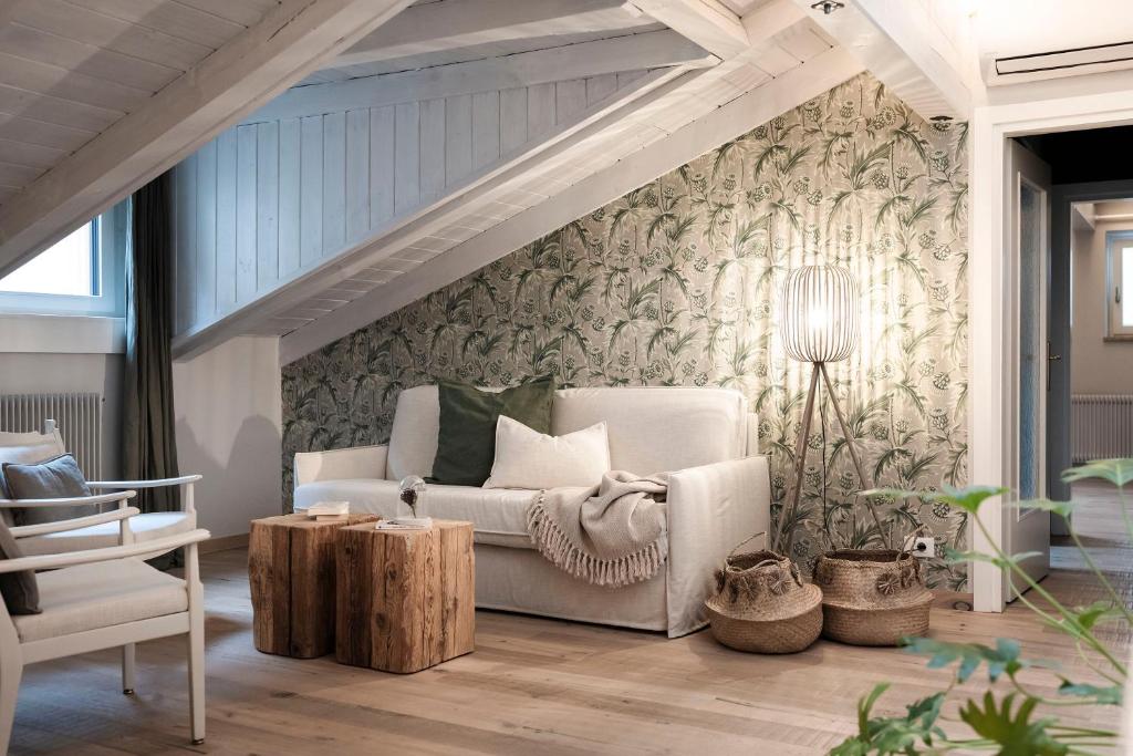a living room with a white couch and a chair at Bogen bistro & apartments in Bolzano