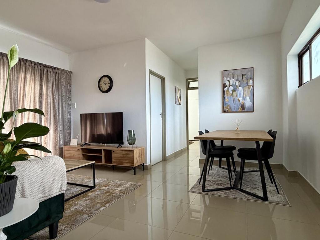 a living room with a table and a television at 2Bedroom Apartment in Pinetown