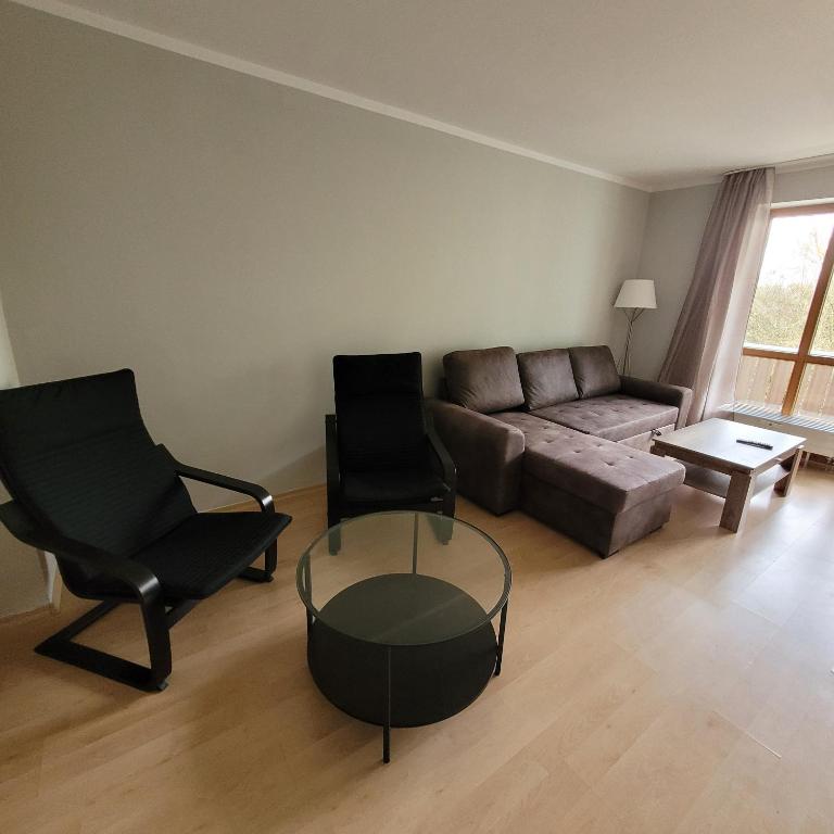 a living room with a couch and two chairs and a table at Moderne 2 Zimmer Appartement in Straubing