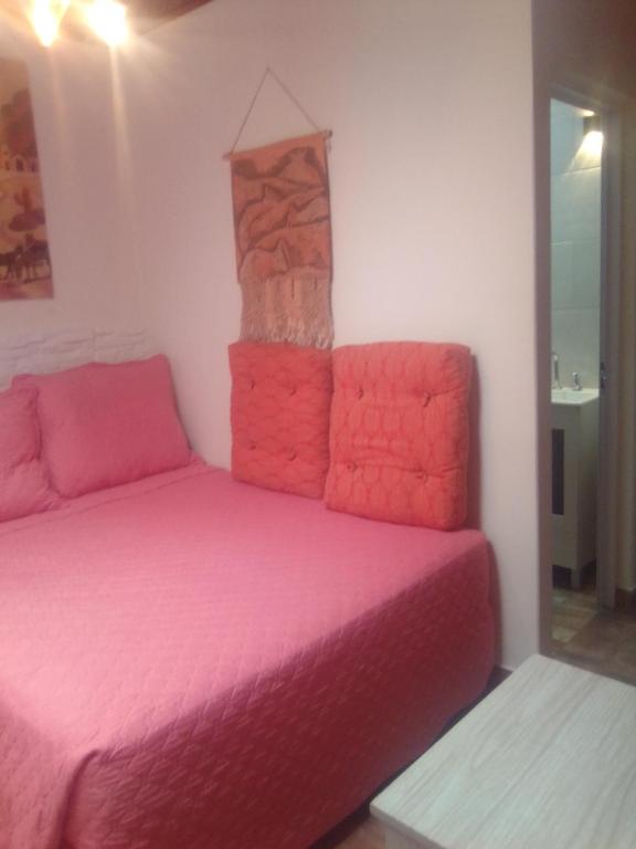 a room with two beds with pink sheets at Killa wasy in Humahuaca