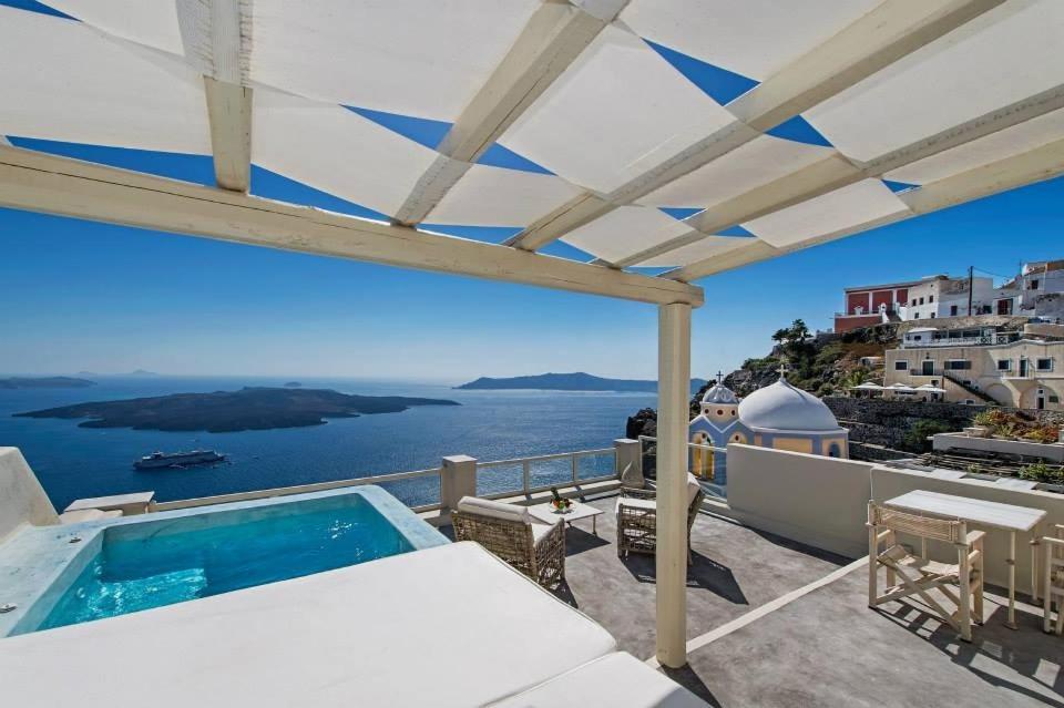 a pool on a balcony with a view of the water at Lava On the Cliff in Fira