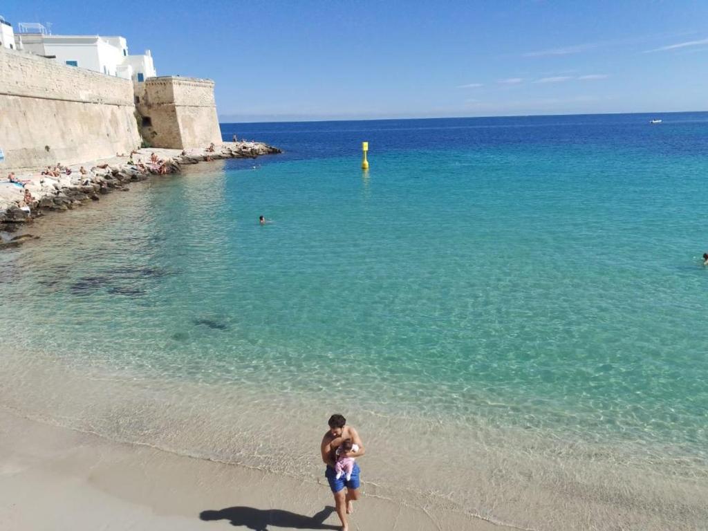 a man walking on the beach near the ocean at Appartamento Selene in Monopoli