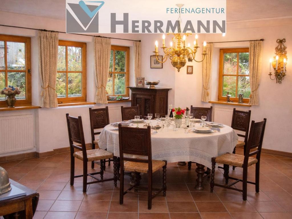 a dining room with a white table and chairs at Landhaus Leu´n Uhl in Füssen