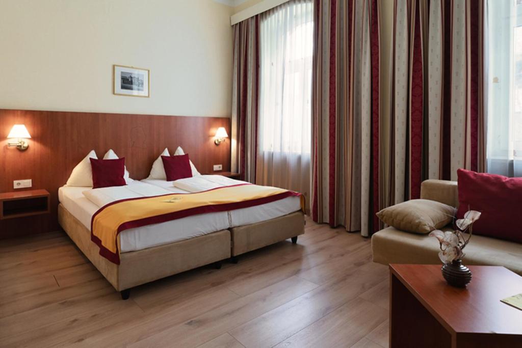 a hotel room with a bed and a couch at Hotel Mozart in Vienna