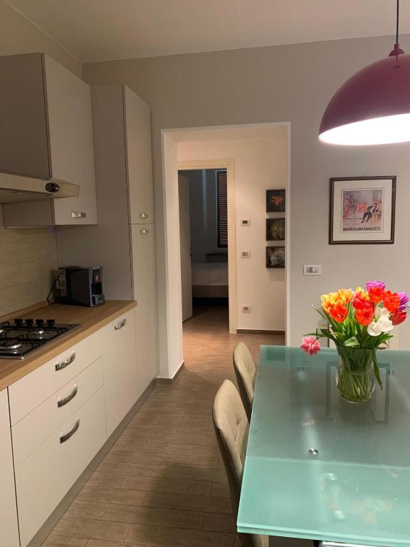 a kitchen with a table with a vase of flowers on it at Casa Pulverun in Domodossola