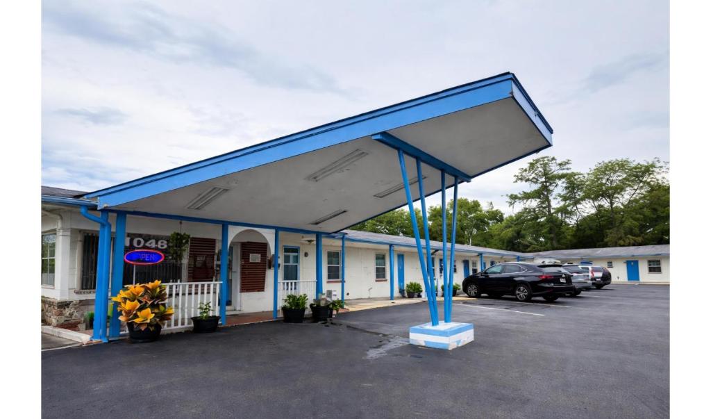 a gas station with a blue canopy in a parking lot at Holiday Motel Ocala Downtown I-75 in Ocala