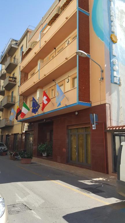 un bâtiment dont les drapeaux sont suspendus sur son côté dans l'établissement Residence Il Sole, à Follonica