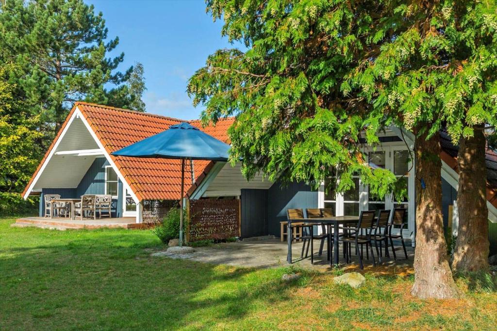 a house with a table and a blue umbrella at 1311-Stege-Rylevej-20 in Stege