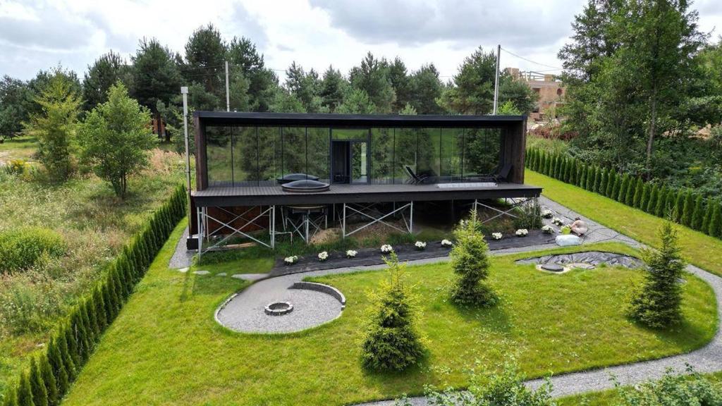 a glass house in the middle of a garden at Neboskhyl House in Khorosno