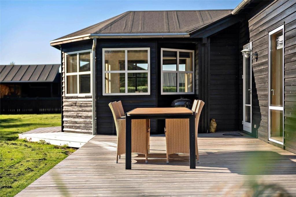 a table and two chairs on a wooden deck at 1306-Stege-Kaerhogevej-64 in Stege