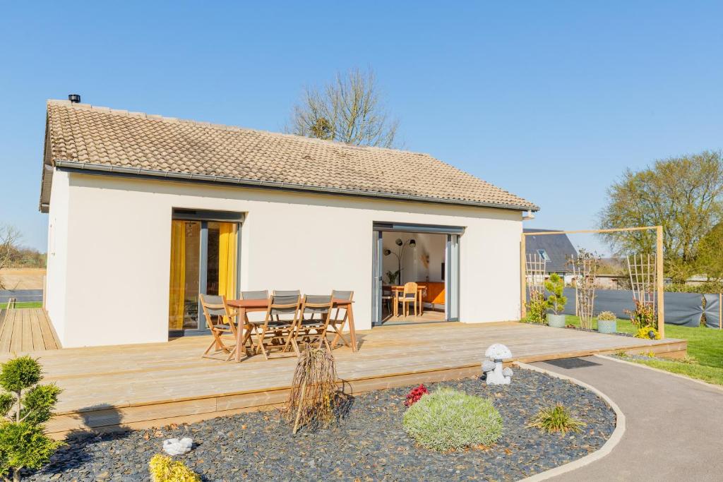 a wooden deck with a table and chairs on it at Gîte Le Nid Des Prés in Cressy