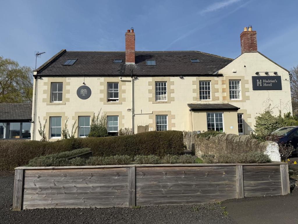a large white house with a fence in front of it at Hadrians Hotel in Chesters