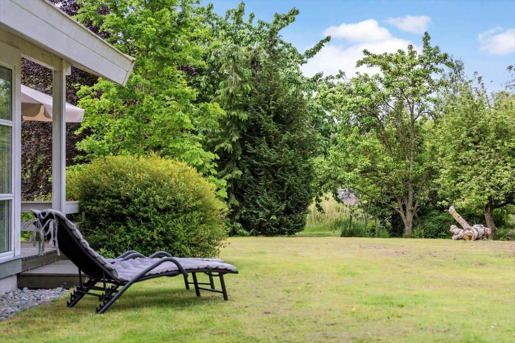 a black chair sitting on the grass next to a house at 1080-Stege-Berberisvej-48 in Stege