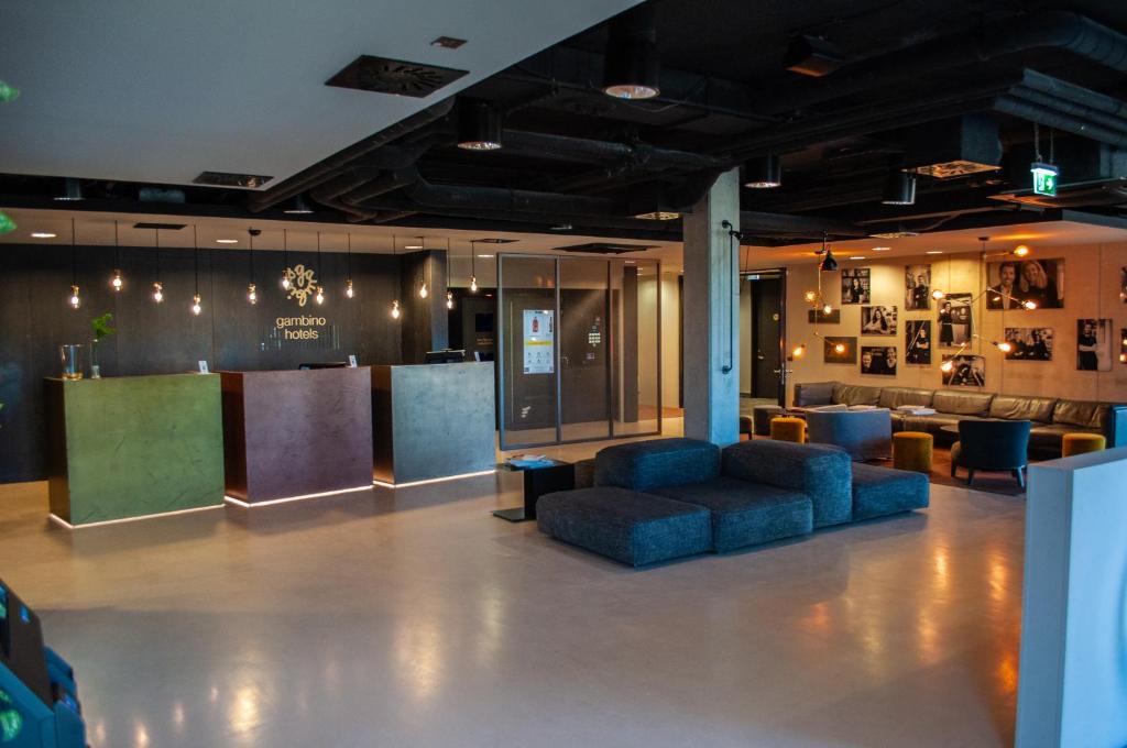 a lobby with couches and a bar in a building at gambino hotel CINCINNATI in Munich