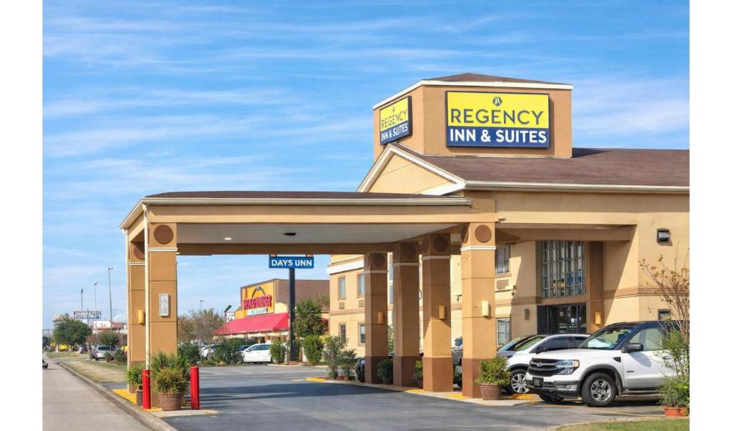a recovery inn and suites building with a parking lot at Regency Inn & Suites Houston East I 10 in Houston