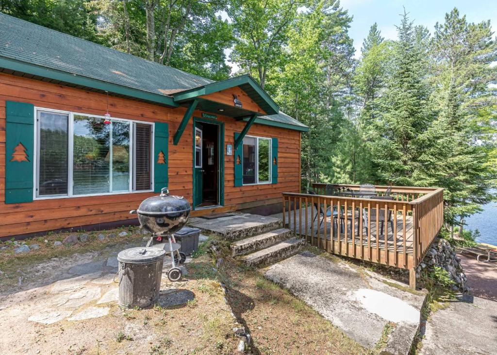 a small house with a grill in front of it at Pinewood - Bouchard Shores Resort in Minocqua