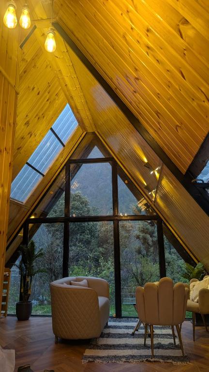 a living room with a vaulted ceiling with windows at Kasol A-Frame Cottage in Kasol
