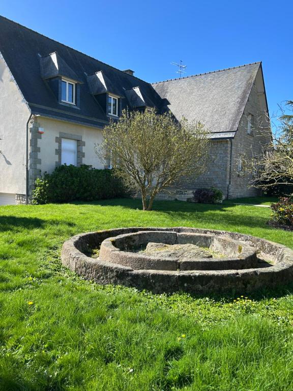 a stone circle in the grass in front of a house at Angel du Mont in Pontorson
