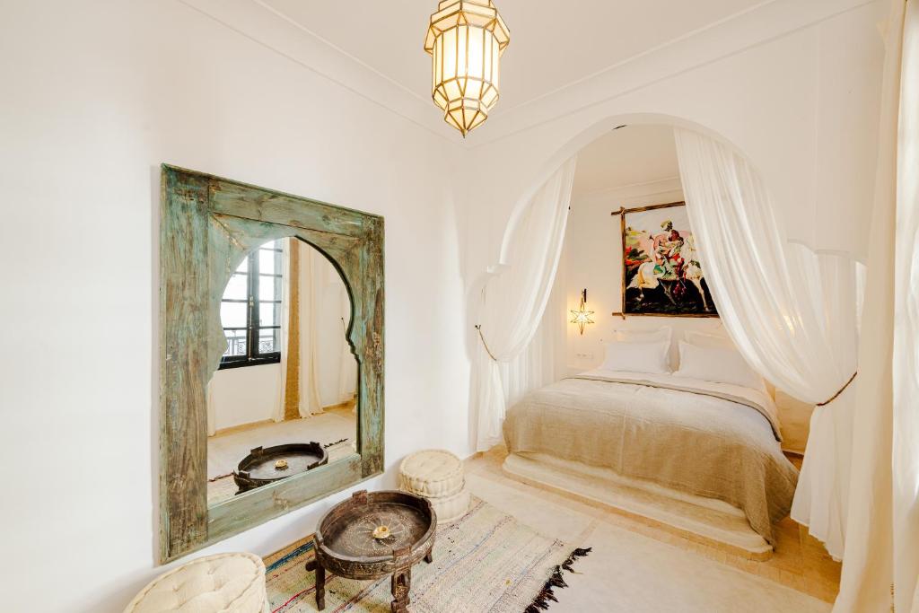 a bedroom with a large mirror and a bed at Riad Taww'Ami in Marrakesh