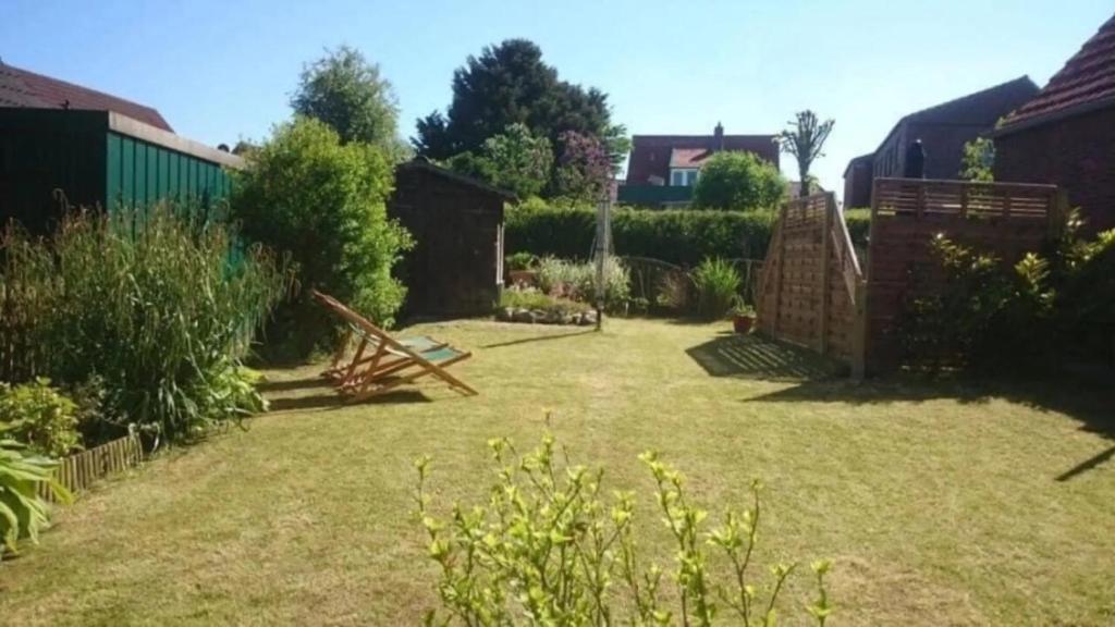 a yard with a garden with a fence at Ferienhaus Leuchtturm in Dornum