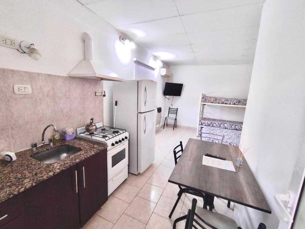 a kitchen with a sink and a refrigerator and a table at Gotas de Rocio N1 in San Antonio Oeste