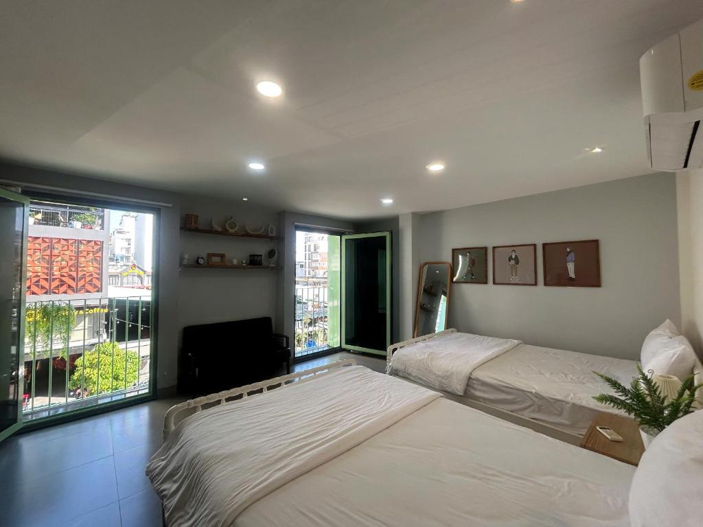 a bedroom with two beds and a large window at Lemon House in Quy Nhon