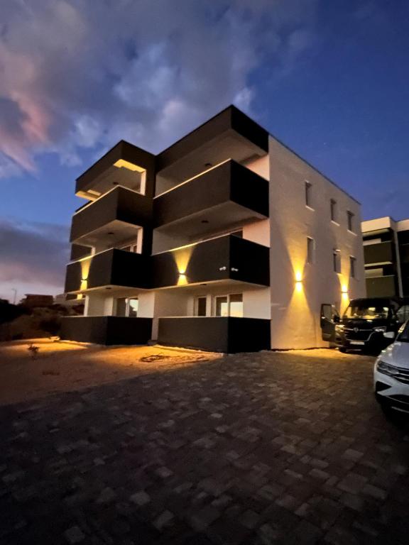 a building with a parking lot in front of it at Astrid Deluxe in Novalja