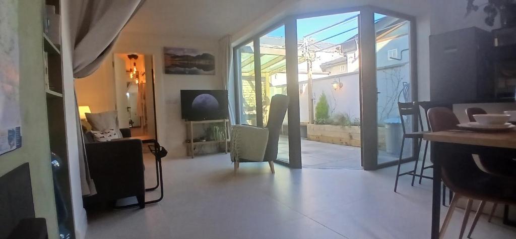 a living room with a glass door and a table and chairs at Stylish Cottage with Loft Sleeps 4 in Dublin