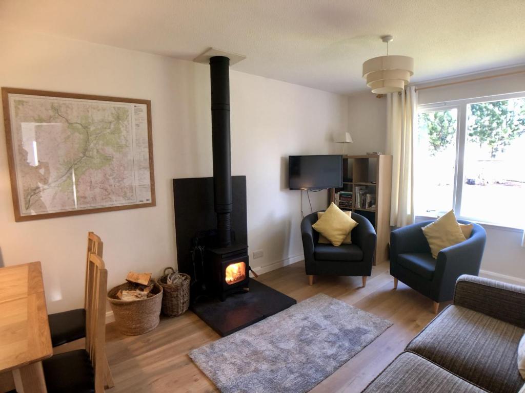 a living room with a wood stove in a room at Silver Birch Cottage in Aviemore