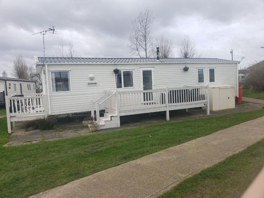 a white mobile home with a porch and a porch at Lapwing 26 in Scratby