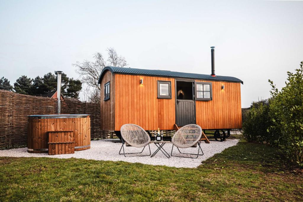 a tiny house with two chairs and a table at Shepherds View in Ashbourne