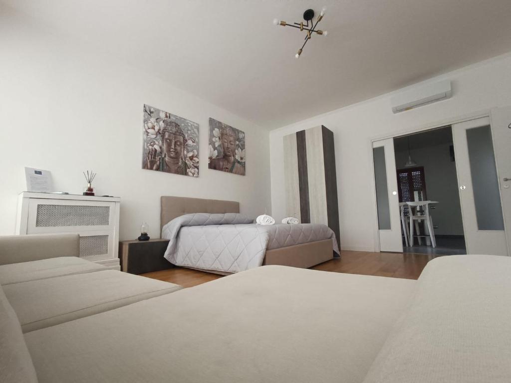 a white bedroom with two beds and a fireplace at Suite Del Redentore 44 in Caserta
