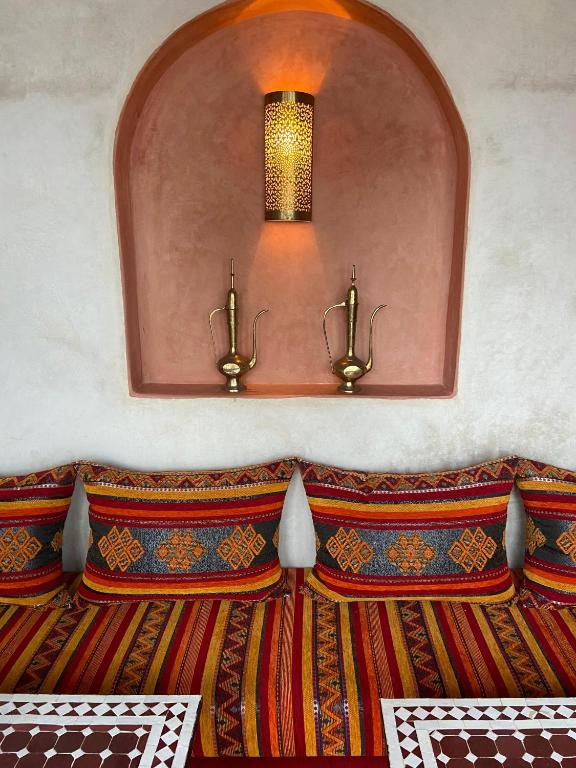 a room with a bed with a light on the wall at riad casa bahia asilah in Asilah
