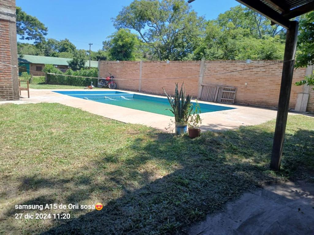 a yard with a swimming pool in a backyard at Cabaña Doña Adela in Paso de la Patria