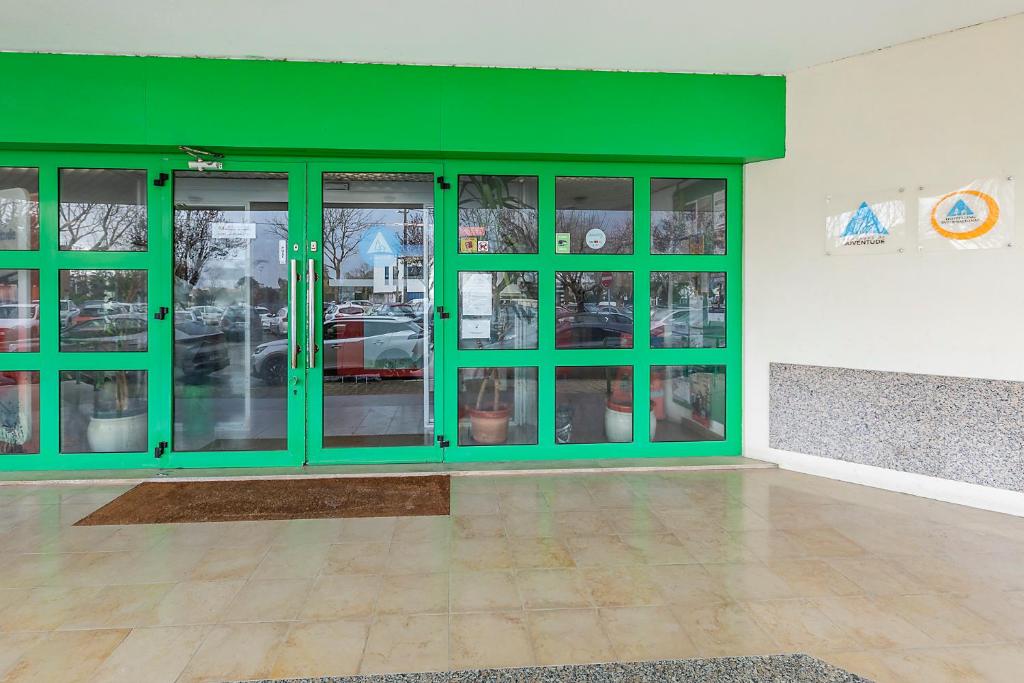 a green room with glass doors in a building at HI Aveiro – Pousada de Juventude in Aveiro