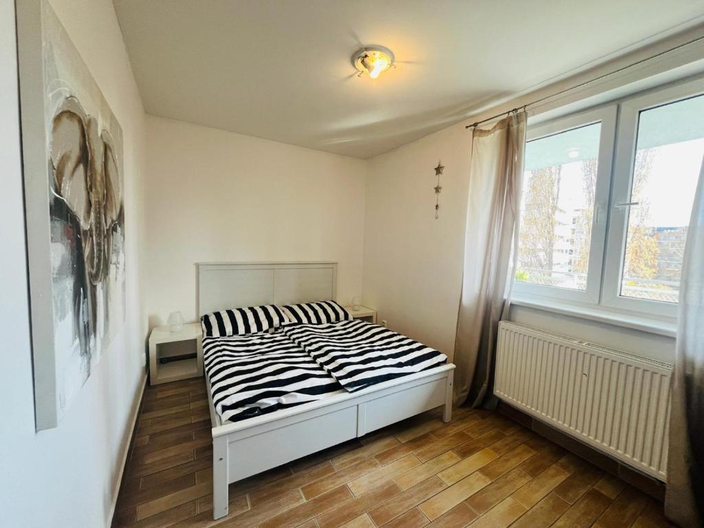 a bedroom with a bed in a room with a window at Appartamento Nivy con posto auto in Bratislava