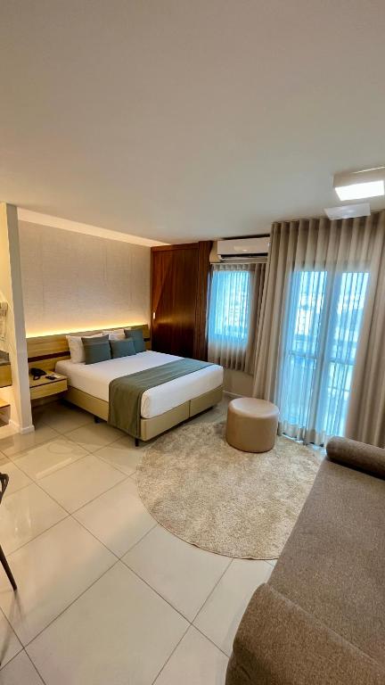 a large bedroom with a bed and a couch at Flat PRAIA de Camburi in Vitória
