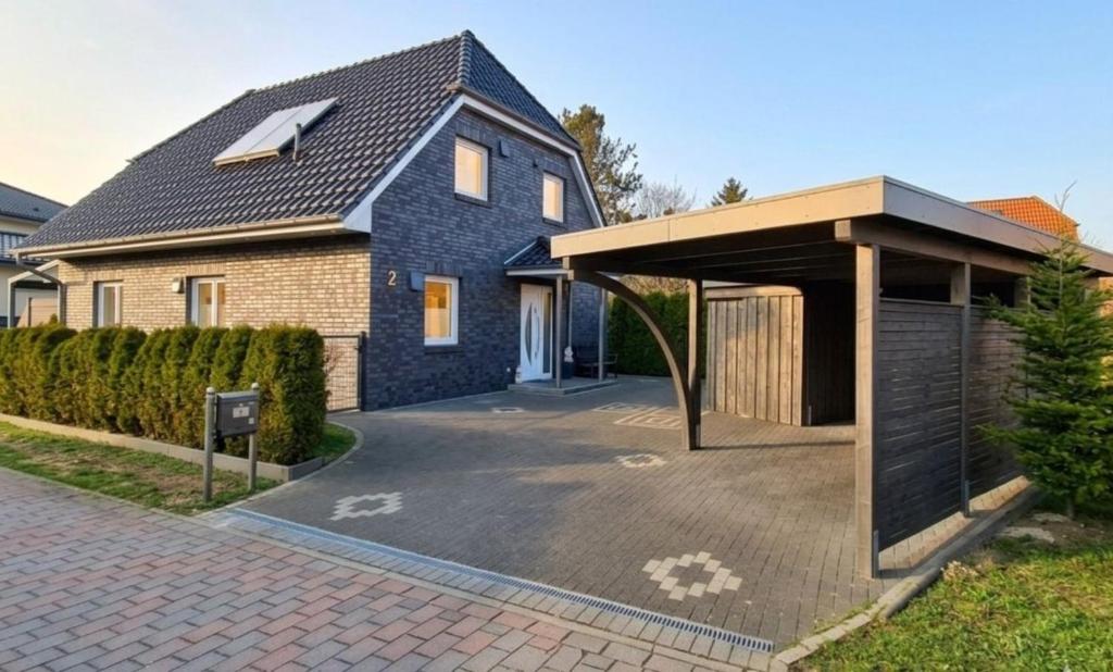 a blue house with a garage and a driveway at Haus Katja in Büdelsdorf