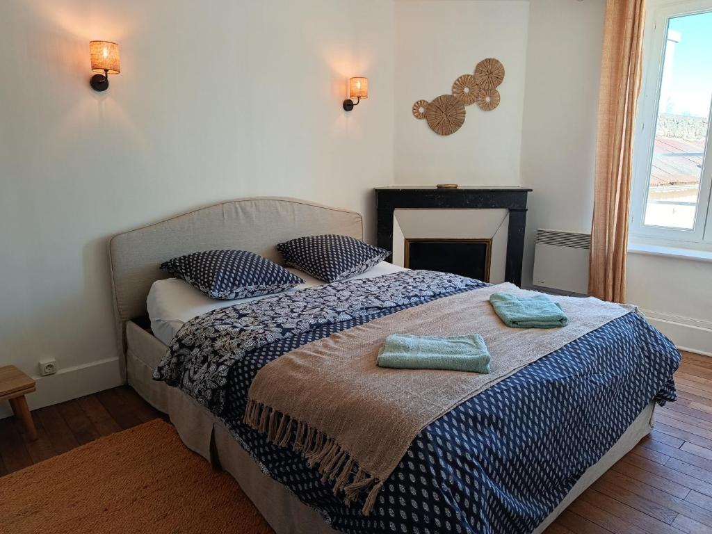 a bedroom with a bed with two towels on it at Appartement Refait a neuf avec accès au jardin , local vélo et Wifi in La Machine