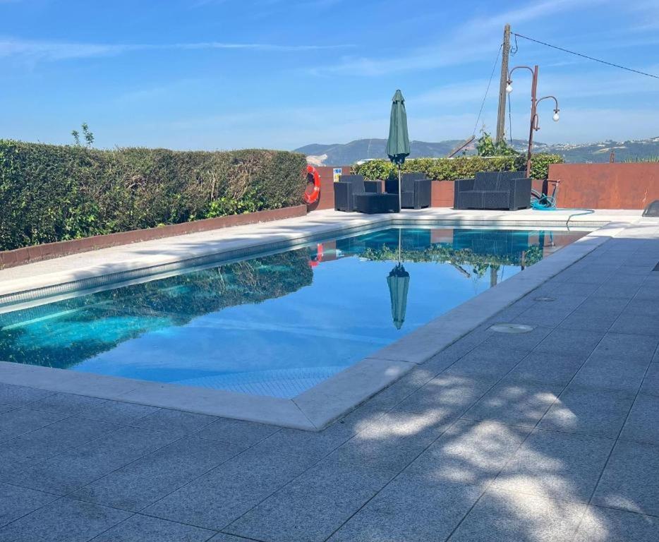 a swimming pool with a reflection in the water at Casa São Domingos 2 in Lousada