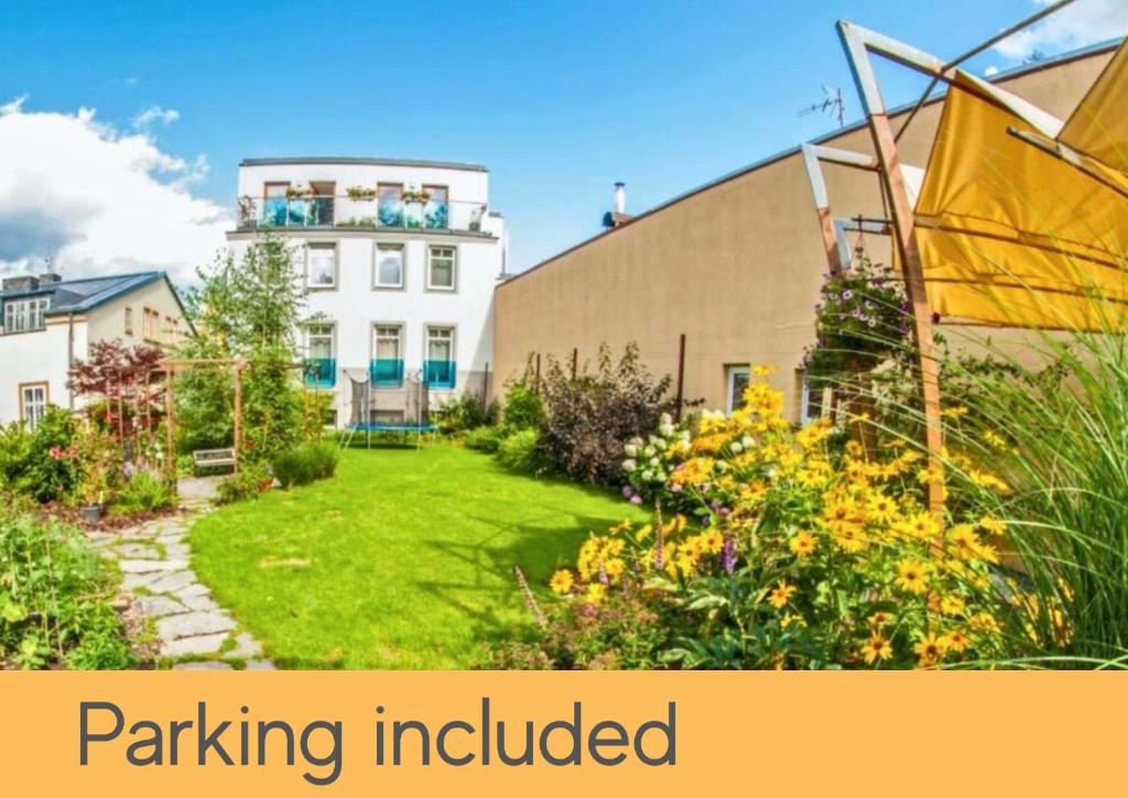 a garden in front of a building with the words parking included at Hygge Hotel U Zvonu in Vrchlabí