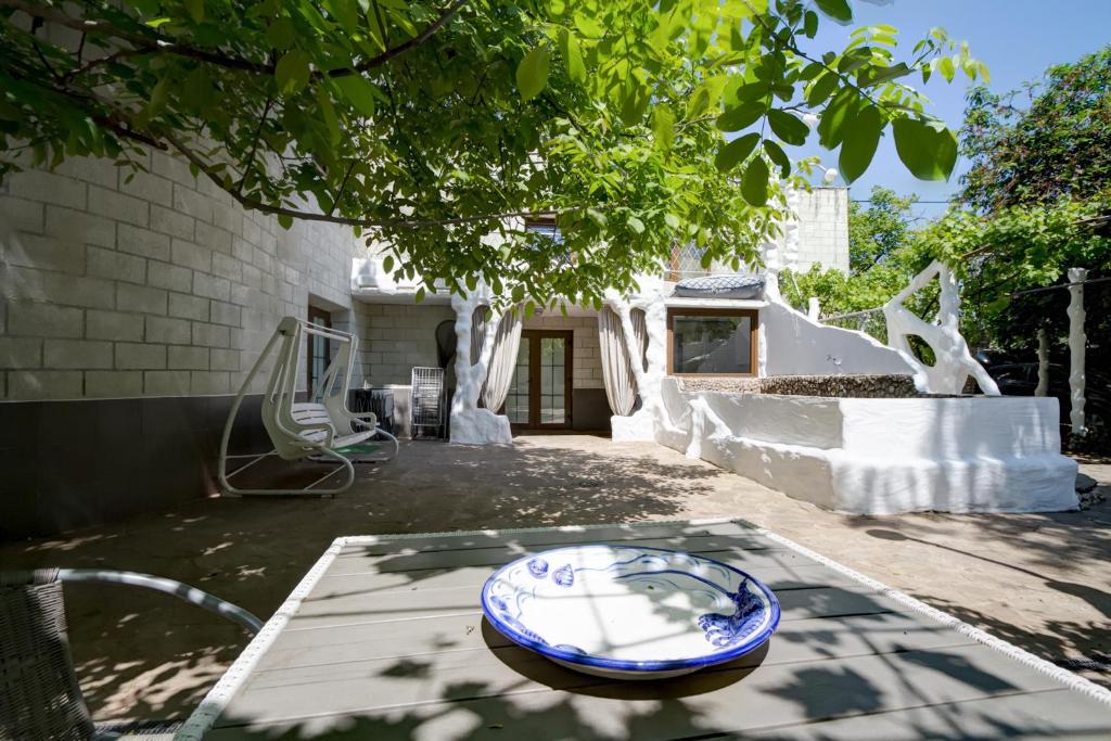 a blue and white bowl on a table in a yard at Villa da Winci in Odesa