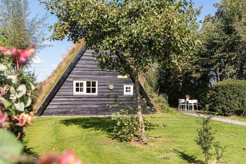 a house with a thatched roof in a garden at Unieke plaggenhut in Drenthe met bedstee & uitzicht op wijngaard in Ruinerwold