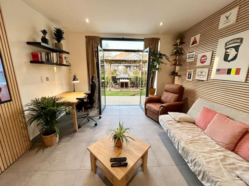 a living room with a couch and a table at Appartement de Standing Plein Centre-Ville "L Atelier de Joss" in Bastogne