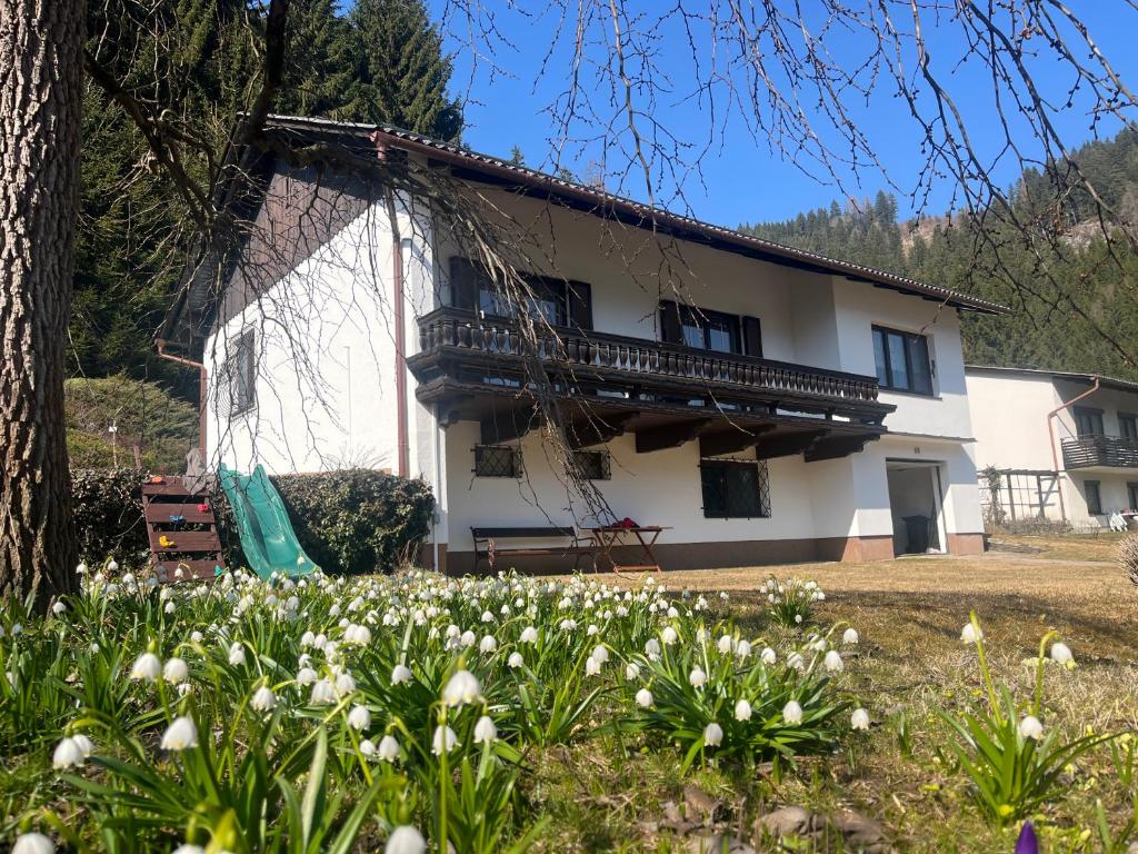 a white house with a balcony and flowers at Forestside Raceway Hideaway in Oberweg
