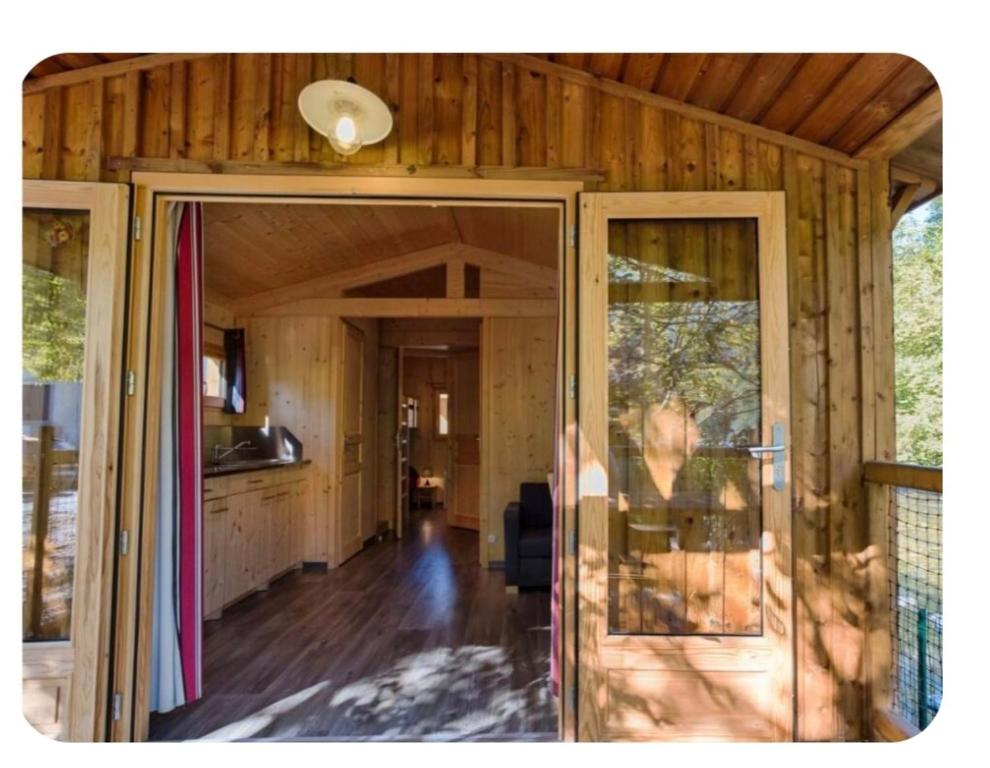an open door of a house with a kitchen at Cabane bois insolite vue montagne piscines famille in Laruns